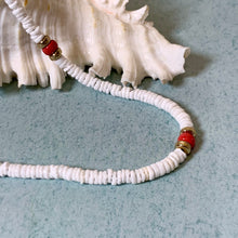 Load image into Gallery viewer, A beaded necklace made of small white shell-like discs with two red and gold spacer beads, arranged on a light blue textured surface next to a white seashell.