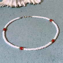 Load image into Gallery viewer, A beaded necklace with white textured beads and four red spacer beads, displayed on a textured blue surface with a white seashell in the background.