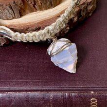 Load image into Gallery viewer, A close-up of a handmade bracelet featuring a raw, irregular white agate stone pendant wrapped in silver wire, resting on a dark burgundy textured surface next to a rustic wood slice.