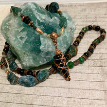 Load image into Gallery viewer, Handcrafted necklace with a green jasper tip pendant, featuring tree agate, black obsidian, and copper accent beads, displayed on a textured background.