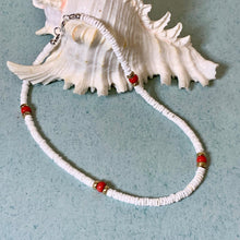 Load image into Gallery viewer, A white beaded necklace with small red and gold spacer beads, displayed on a light blue surface next to a white seashell.