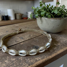 Load image into Gallery viewer, Shell belt on a wooden surface with a plant in the background