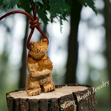 Load image into Gallery viewer, A leather cord choker necklace with a carved picture jasper bear totem pendant, displayed against a natural backdrop.