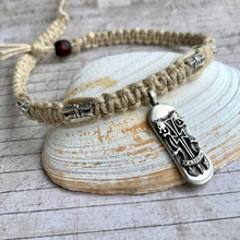 Load image into Gallery viewer, A beige thick hemp necklace with a surfboard cross pendant, displayed on a white seashell.