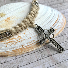 Load image into Gallery viewer, A handcrafted thick hemp necklace with a Celtic cross pendant, displayed on a textured background.