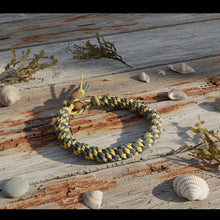 Load image into Gallery viewer, Bracelet with yellow and gray pattern on a wooden surface with shells and seaweed
