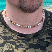 Load image into Gallery viewer, A man wearing a choker necklace with white puka shell beads, blue glass beads, and coconut beads.
